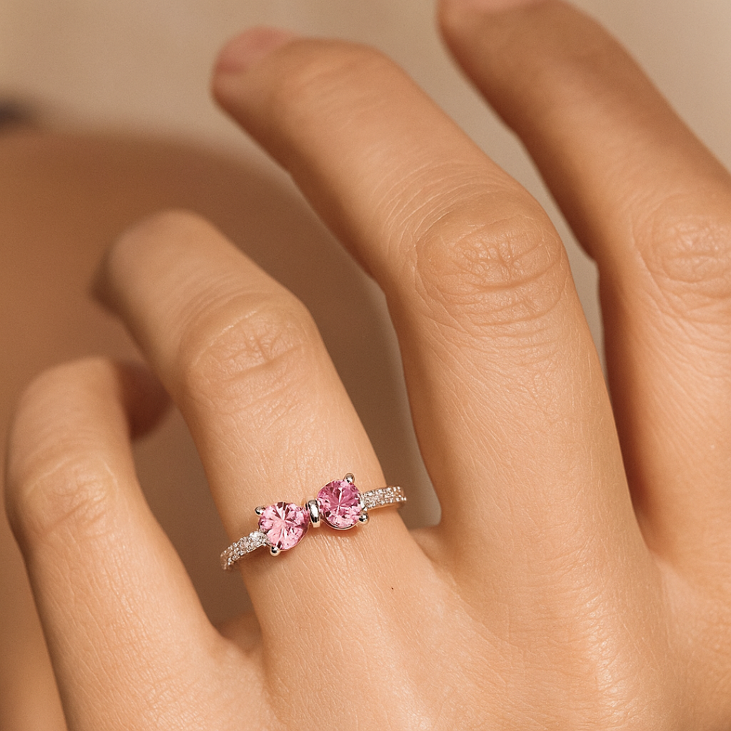 Delikat ring formet som en sløjfe med sølvbånd og pink eller hvide cubic zirconia-sten