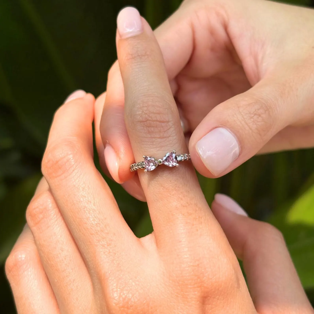 Delikat ring formet som en sløjfe med sølvbånd og pink eller hvide cubic zirconia-sten