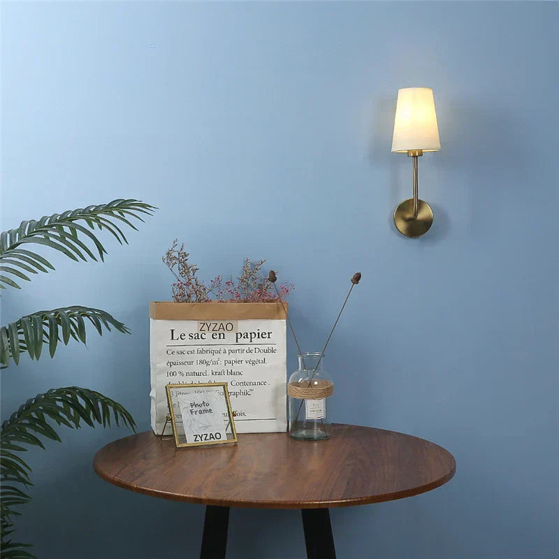 Lámpara de pared con brazo de latón cálido y pantalla de lino para pasillos y corredores