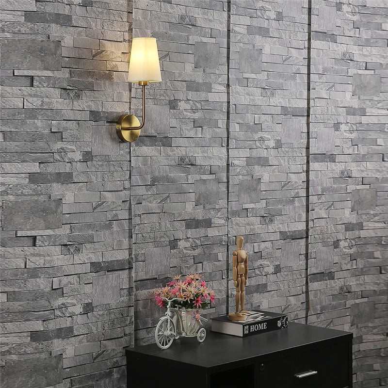 Lámpara de pared con brazo de latón cálido y pantalla de lino para pasillos y corredores
