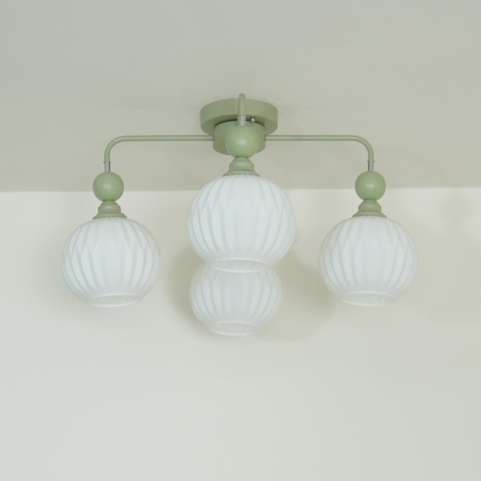 Plafonnier Lumencrest avec abat-jours en verre blanc côtelé et cadre métallique vert